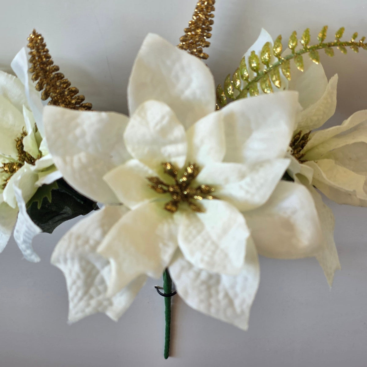 Close-up of ivory and gold sparkle artificial poinsettia flower