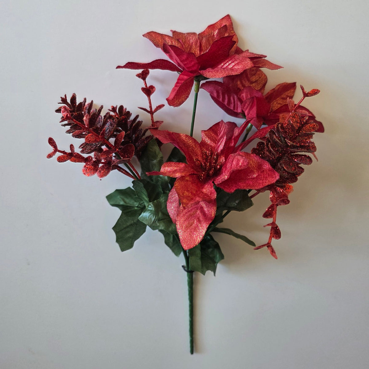 Red shimmer Christmas poinsettia flower bunch with pine cones